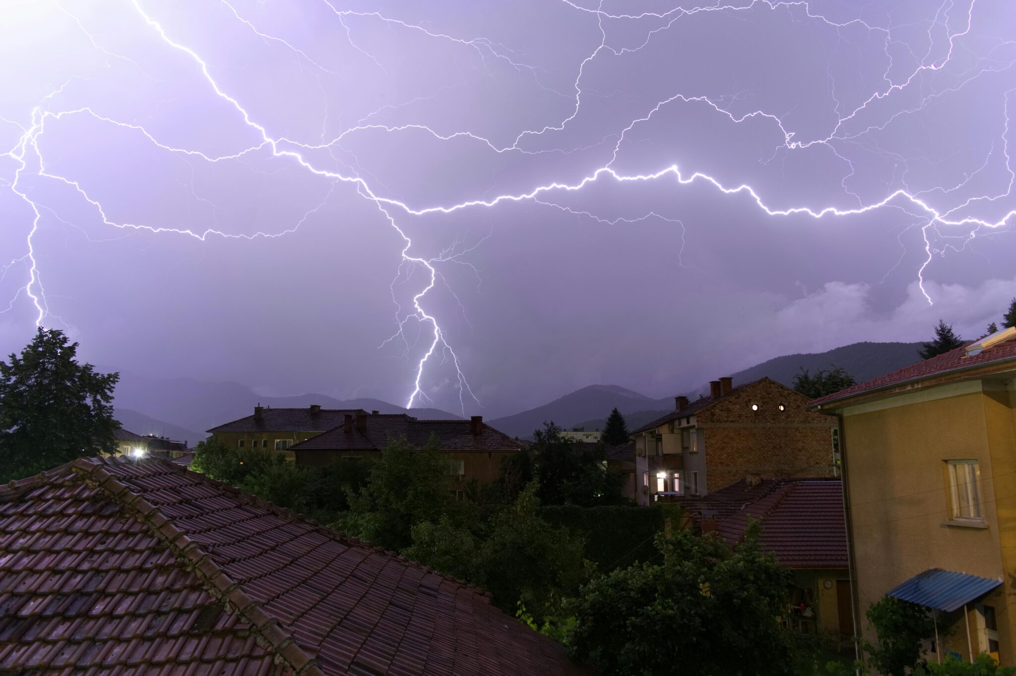 Stunning lightning storm over rooftops in Botevgrad, Bulgaria, showcasing nature's power.