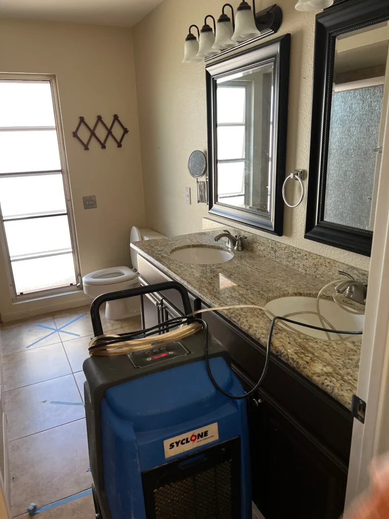 Professional water extraction team removing standing water from a bathroom floor in a Nashville home.